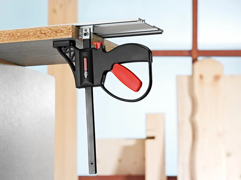 แคลมป์อุปกรณ์เสริมระบบสำหรับยึดแผ่นไม้กับพื้นผิวโลหะในโรงงาน.