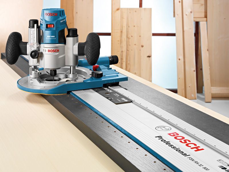 เราเตอร์ไฟฟ้านำทางตามรางโลหะบนพื้นผิวการทำงานไม้.