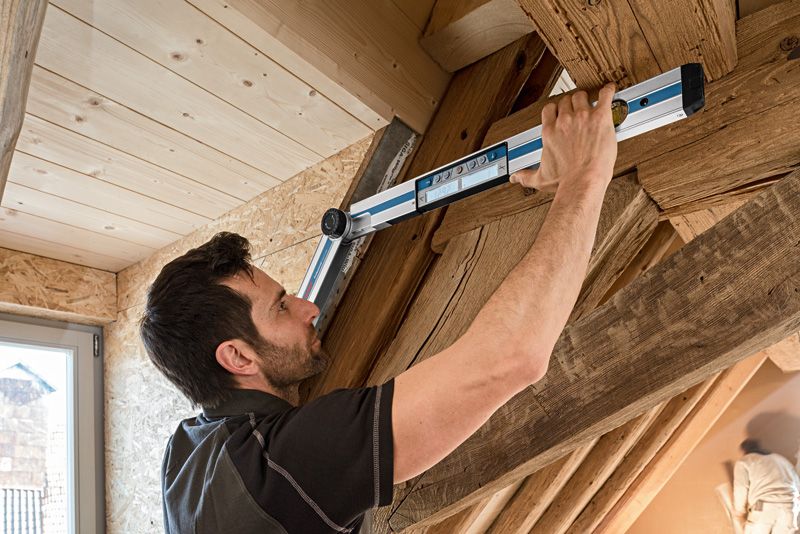 คนวัดมุมระหว่างคานไม้ด้วยเครื่องวัดมุม