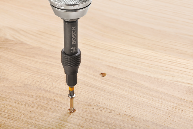 สว่านไฟฟ้ากำลังขันสกรูเข้าไปในแผ่นไม้