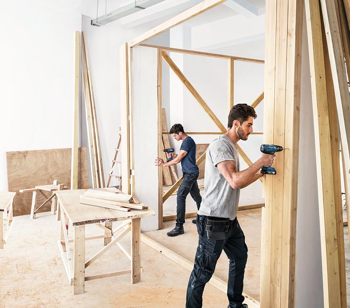 ชายสองคนกำลังสร้างกำแพงไม้.