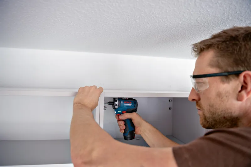 GSR 12V-35 HX บุคคลที่สวมอุปกรณ์ความปลอดภัยใช้ไขควงไร้สายในการประกอบตู้.