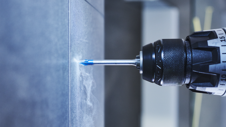 สว่านไฟฟ้ากำลังเจาะรูในผนังกระเบื้อง