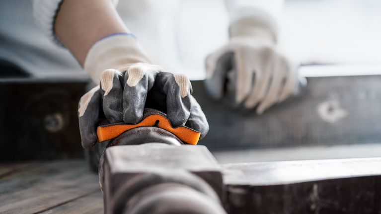 บุคคลที่สวมอุปกรณ์ความปลอดภัยกำลังจัดแนวท่อโดยใช้ระดับน้ำ