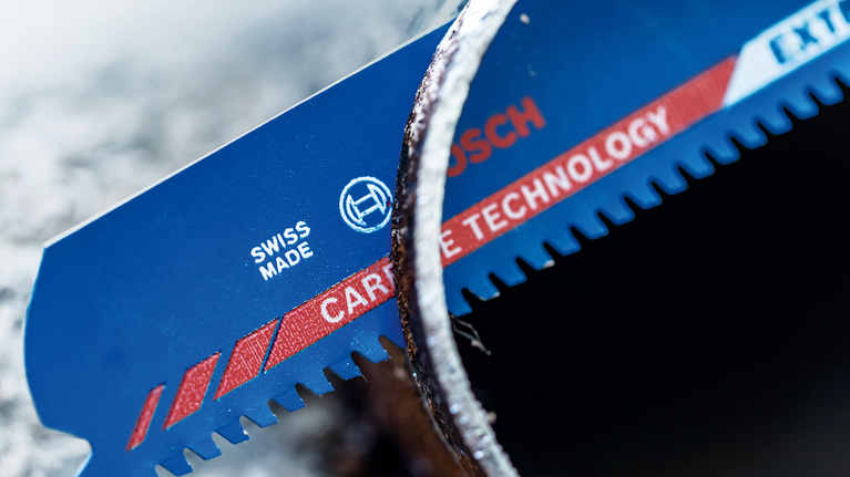 ใบเลื่อยอเนกประสงค์ EXPERT Thick Tough Metal S 955 CHC จำนวน 1 ชิ้น ภาพระยะใกล้ของใบเลื่อยสีน้ำเงินที่มีฟันคาร์ไบด์ตัดผ่านท่อโลหะ