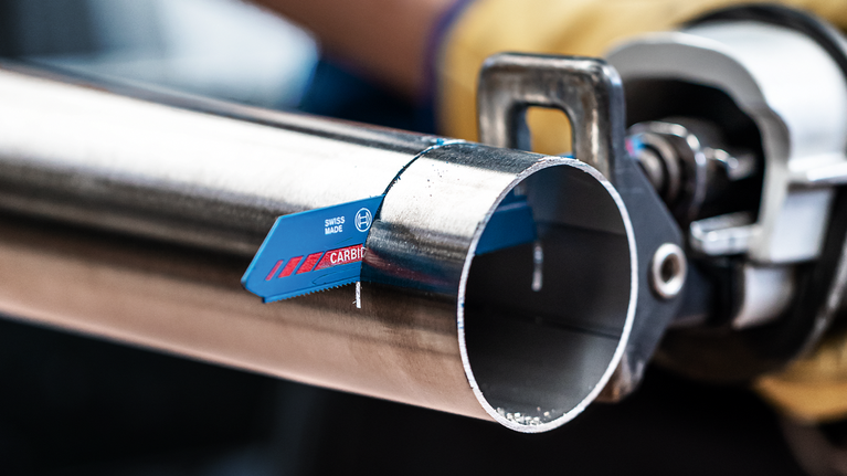 บุคคลที่สวมอุปกรณ์ด้านความปลอดภัยใช้เลื่อยตัดโลหะ