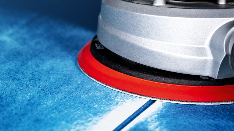 เครื่องมือไฟฟ้าฐานสีแดงขัดพื้นผิวสีน้ำเงิน