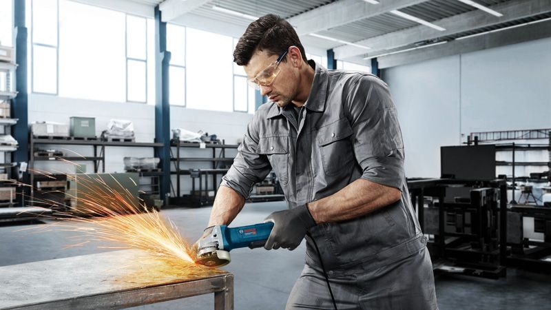 ชายกำลังบดโต๊ะโลหะ.