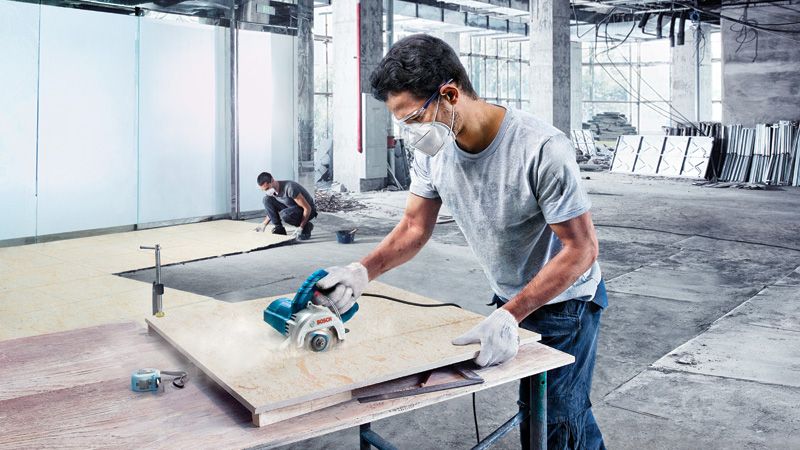 เครื่องตัดกระเบื้องเพชร Bosch GDC 140 ใช้งานอยู่ในไซต์งาน.