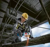 บุคคลที่สวมอุปกรณ์ด้านความปลอดภัยใช้เครื่องเจียรไร้สายในการตัดโลหะ.