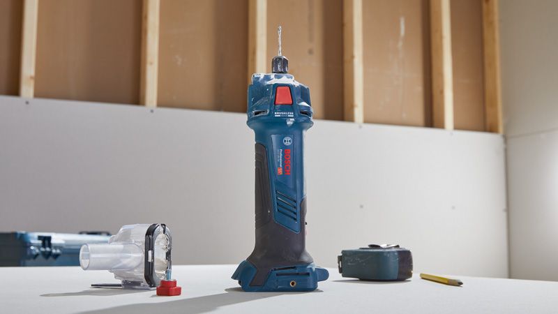 เราเตอร์ drywall แบบไร้สายตั้งตรงบนโต๊ะข้างๆ อุปกรณ์เสริมและดินสอ.