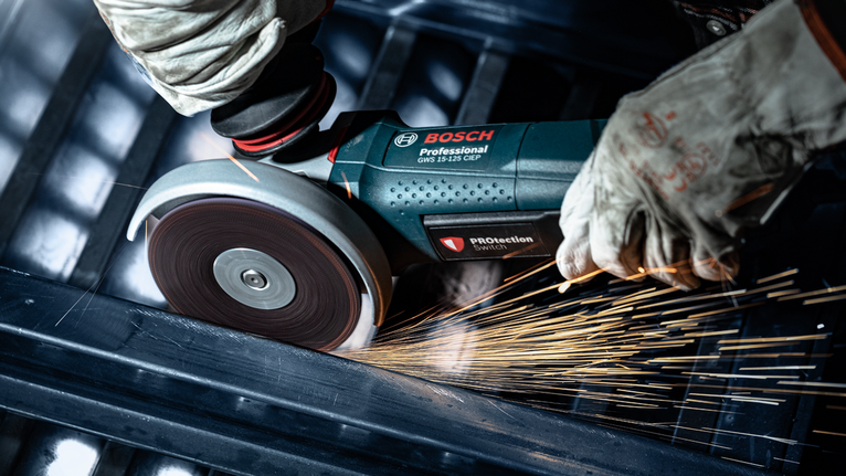 บุคคลที่สวมอุปกรณ์ความปลอดภัยใช้เครื่องเจียรตัดโลหะ จึงเกิดประกายไฟขึ้น