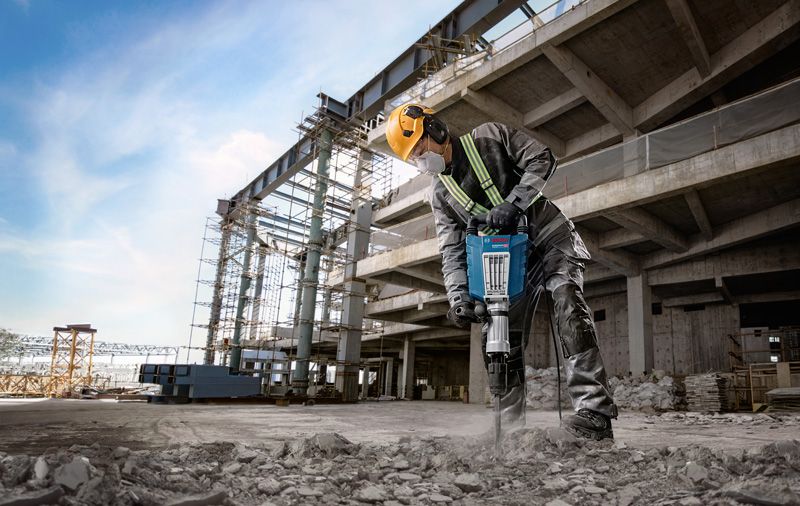 คนงานกำลังใช้เครื่องเจาะกระแทกในสถานที่.