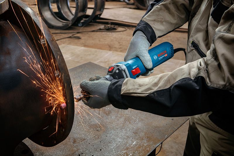 ผู้ที่สวมอุปกรณ์ป้องกันความปลอดภัยกำลังบดโลหะ ทำให้เกิดประกายไฟสว่าง.