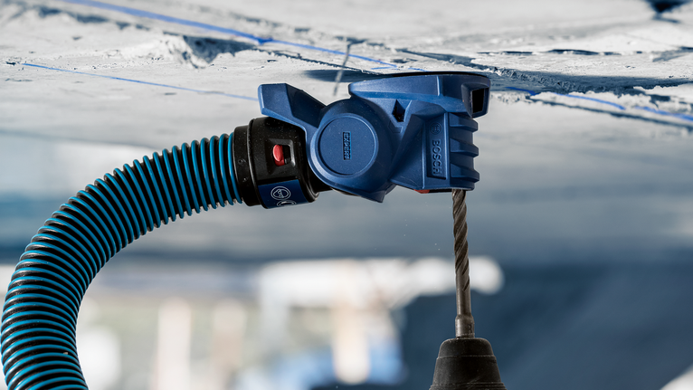 อุปกรณ์ดูดฝุ่นที่เชื่อมต่อกับสว่านเพื่อสร้างรูบนเพดานคอนกรีต