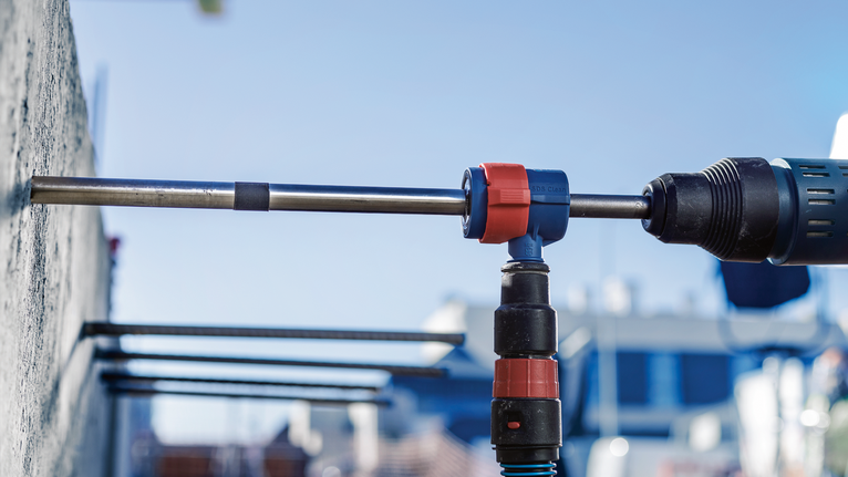 การใช้สว่านโรตารี่เจาะรูในผนังคอนกรีตกลางแจ้ง