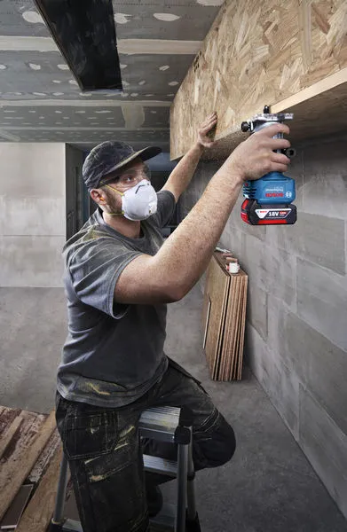 ผู้ที่สวมอุปกรณ์ความปลอดภัยใช้เราเตอร์บนชั้นไม้.