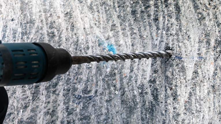 การเจาะด้วยค้อนโรตารี่เข้าไปในผนังคอนกรีต