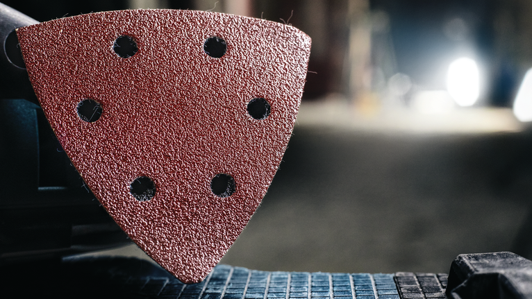 มุมมองรายละเอียดของแผ่นขัดสามเหลี่ยมที่ติดอยู่กับเครื่องมือไฟฟ้า