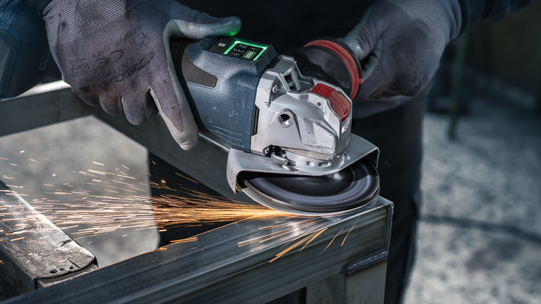 บุคคลที่สวมอุปกรณ์ความปลอดภัยทำการเจียรโลหะ ทำให้เกิดประกายไฟ