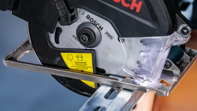 เลื่อยไฟฟ้าตัดผ่านคานโลหะพร้อมแผ่นป้องกันติดตั้งอยู่