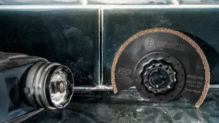 ใบเลื่อยวงเดือนคาร์ไบด์วางอยู่บนพื้นผิวกระเบื้องถัดจากเครื่องมือไฟฟ้า