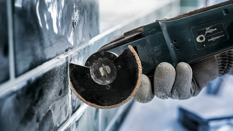 บุคคลที่สวมอุปกรณ์ความปลอดภัยใช้เครื่องมือไฟฟ้าตัดกระเบื้อง