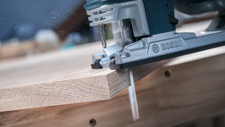 จิ๊กซอว์ตัดผ่านแผ่นไม้ในโรงงาน