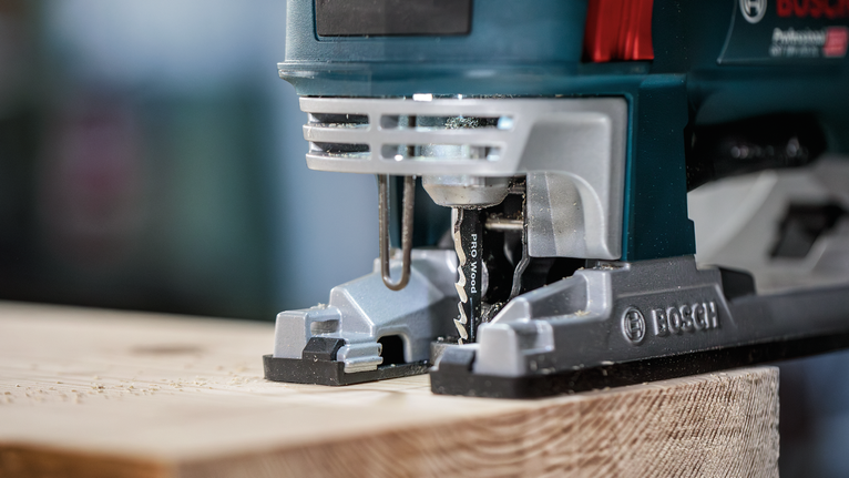 จิ๊กซอว์ตัดผ่านแผ่นไม้ในโรงงาน