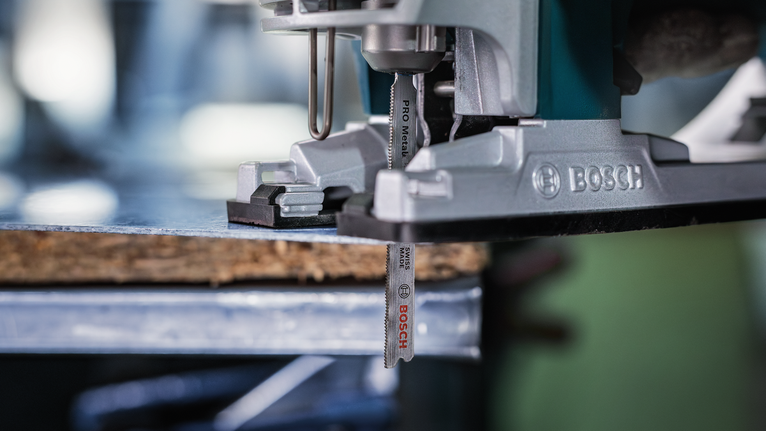 จิ๊กซอว์ตัดผ่านชิ้นไม้บนโต๊ะทำงาน