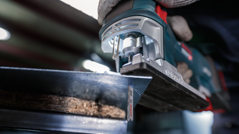 บุคคลที่สวมอุปกรณ์ความปลอดภัยกำลังตัดไม้ด้วยจิ๊กซอว์