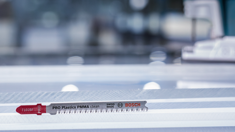 ใบเลื่อยจิ๊กซอว์วางอยู่บนแผ่นพลาสติกใสในห้องทำงาน