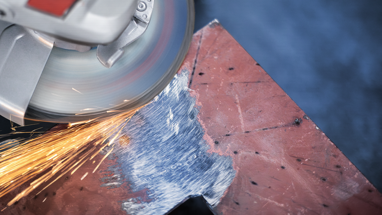 เครื่องเจียรไฟฟ้าทำให้เกิดประกายไฟขณะขัดขอบแผ่นโลหะ