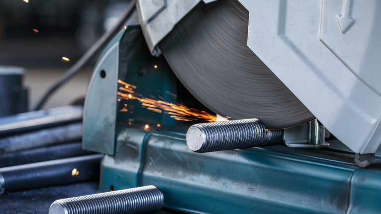 ใบเลื่อยตัดโลหะตัดผ่านแท่งเหล็ก ทำให้เกิดประกายไฟพุ่งออกมา