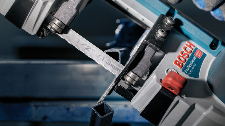 ใบเลื่อย PRO CB2824 Band, 733 มม., 2 ชิ้น ใบเลื่อยสายพานโลหะกำลังตัดผ่านท่อเหล็กสี่เหลี่ยมในโรงงาน