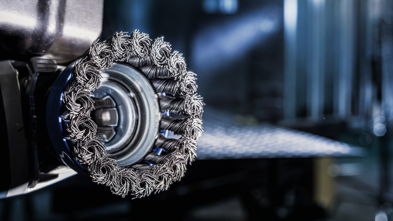 ภาพระยะใกล้ของหัวแปรงลวดบนเครื่องมือไฟฟ้าในโรงงานอุตสาหกรรม