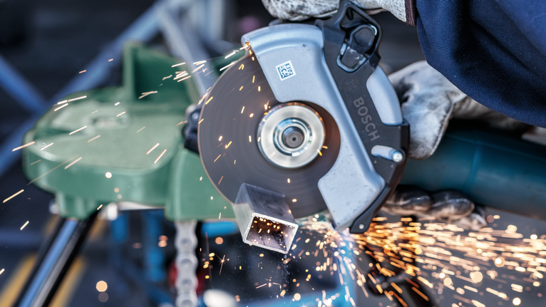 ผู้ที่สวมอุปกรณ์นิรภัยตัดท่อโลหะด้วยเครื่องเจียร ทำให้มีประกายไฟกระเด็นออกมา