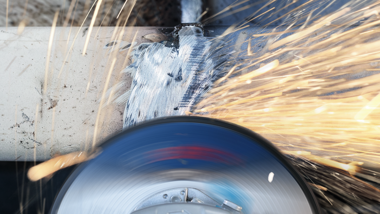 เครื่องมือเจียรสำหรับขัดท่อโลหะให้มีประกายไฟสว่างวาบออกมา