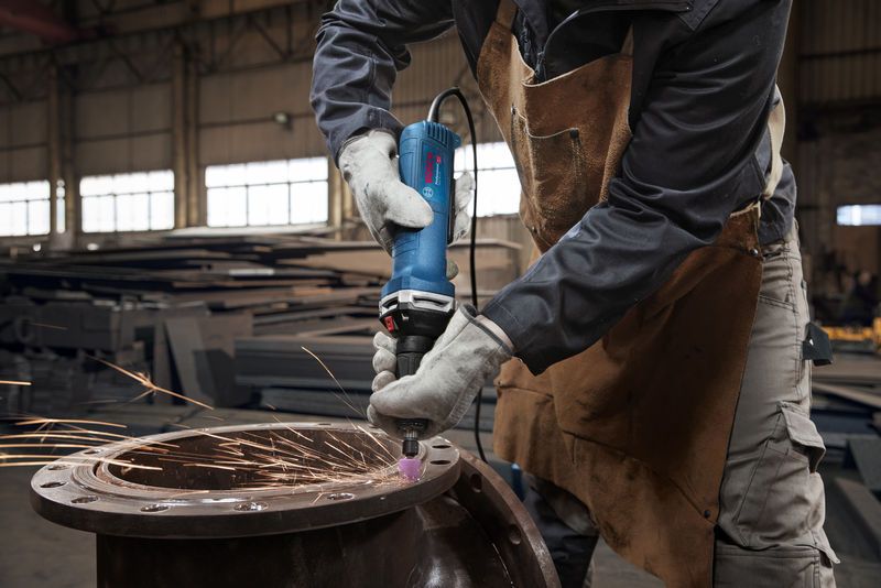 บุคคลที่สวมอุปกรณ์ด้านความปลอดภัยกำลังเจียรโลหะด้วยเครื่องเจียรตรง ทำให้เกิดประกายไฟ.
