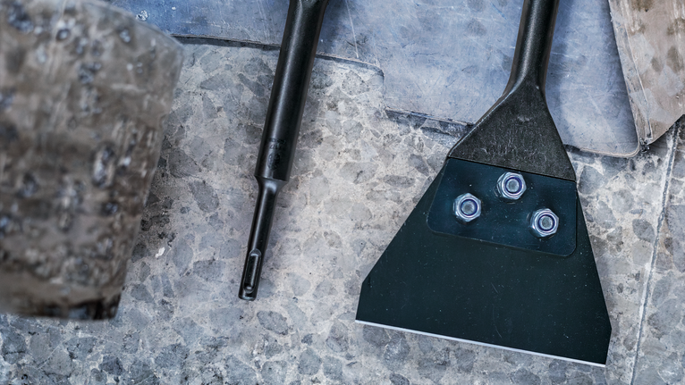 อุปกรณ์สิ่วและเครื่องมือขูดวางอยู่บนพื้นผิวหิน