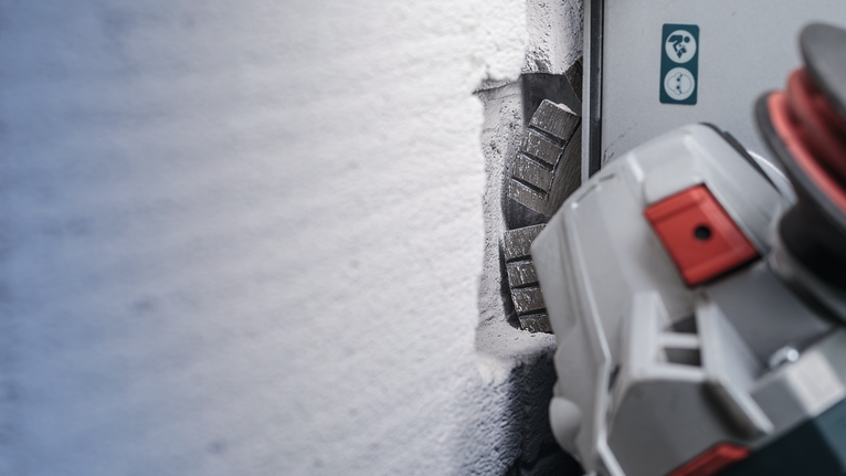 เครื่องเซาะผนังกำลังตัดร่องตรงในผนังคอนกรีต