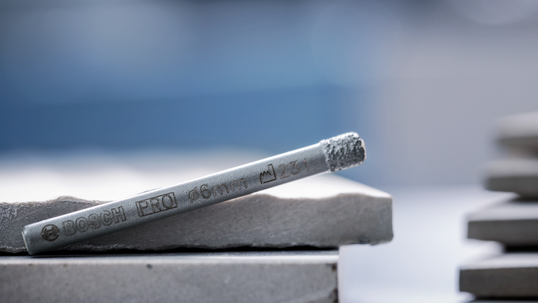 ดอกสว่านโลหะวางอยู่บนกระเบื้องเซรามิกที่วางซ้อนกัน