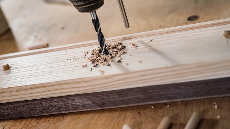 เจาะรูบนแผ่นไม้บนโต๊ะทำงาน