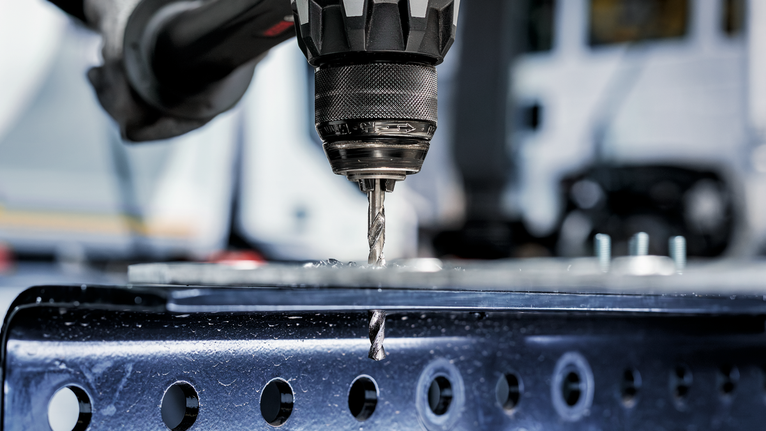 สว่านไฟฟ้าเจาะรูบนคานโลหะ