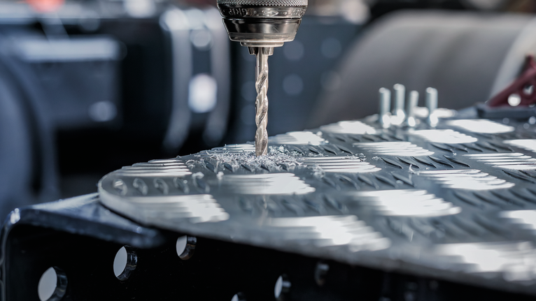 สว่านจะสร้างรูบนแผ่นโลหะที่มีพื้นผิว