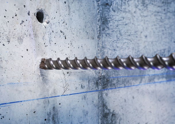 ดอกสว่านเจาะปูนขนาดใหญ่เจาะเข้าไปในผนังคอนกรีต