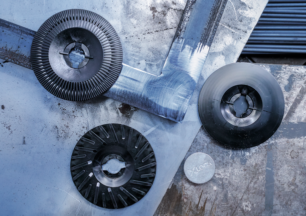 แผ่นเจียรและตัดโลหะ 3 แผ่นวางอยู่บนพื้นผิวโลหะที่เป็นรอยขีดข่วน