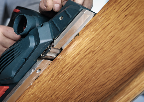 ผู้ใช้ใช้เครื่องไสไม้ไฟฟ้าเพื่อปรับขอบกระดานไม้ให้เรียบ