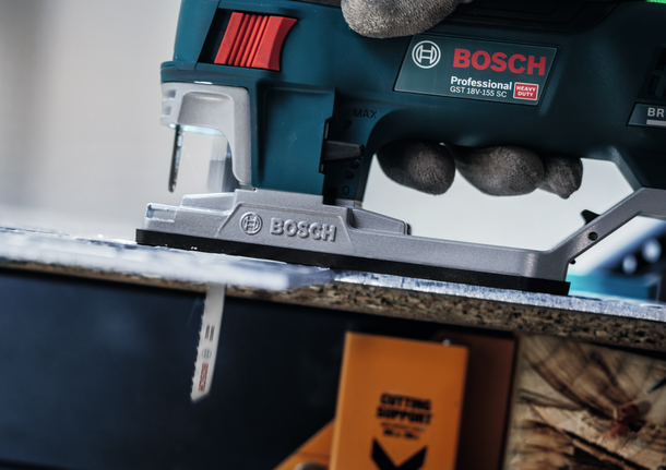 บุคคลที่สวมอุปกรณ์ความปลอดภัยใช้จิ๊กซอว์ตัดแผ่นไม้