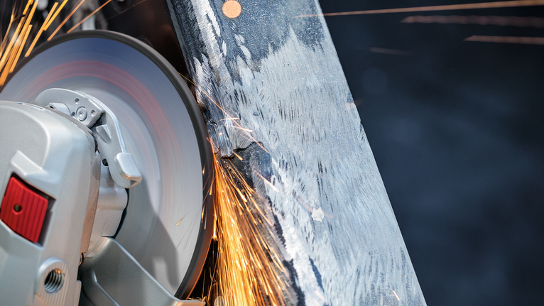ล้อตัดจะสร้างประกายไฟในขณะที่ตัดผ่านลำแสงโลหะ.